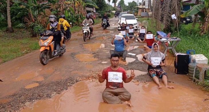 Ekspresi Warga Berpose Seperti Model di Jalan Berlobang